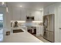 Bright kitchen with stainless steel appliances, white cabinets, and quartz countertops at 7651 Whisper Way # 104, Reunion, FL 34747