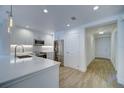 Modern kitchen featuring white cabinets, stainless steel appliances, and wood-look flooring, all brightly lit at 7651 Whisper Way # 104, Reunion, FL 34747
