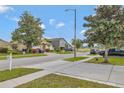 Neighborhood street view of homes with well-manicured lawns and mature trees at 7718 Cafaro Dr, Orlando, FL 32818