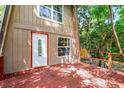 Close-up of the front exterior with a red wood deck, white door, and new windows at 7807 Napoleon St, Orlando, FL 32825