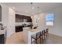 Kitchen boasts dark cabinets, granite countertops, stainless steel appliances, and island with bar seating at 9153 Harris Hawk Dr, Leesburg, FL 34788