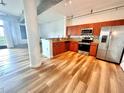Modern kitchen with stainless steel appliances, wood cabinets, granite counters, and wood floors at 10 N Summerlin Ave # 25, Orlando, FL 32801
