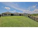 Expansive backyard featuring lush green grass and a sleek black fence at 11725 Language Way, Orlando, FL 32832