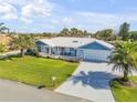 Aerial view of a charming single-story home with a well-manicured lawn and attached garage at 120 Sand Dunes Dr, Ormond Beach, FL 32176
