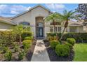 Inviting front entrance with a blue front door, manicured landscaping, and large windows at 14313 Roxshire Dr, Orlando, FL 32837