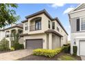A two-story home featuring neutral stucco, a clay tile roof, and a spacious garage with brick-paved driveway at 1539 Corolla Ct, Reunion, FL 34747