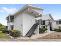 Exterior view showing a two-story condo with stair access to the upper unit and screened porch at 1550 11Th Ne St # H-4, Winter Haven, FL 33881