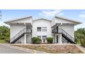 Exterior view of a two-story condo featuring private entrances with stairs and well-maintained landscaping at 1550 11Th Ne St # H-4, Winter Haven, FL 33881