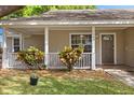 Inviting front porch with white railings and colorful foliage flanking the front door at 1563 Dess Dr, Orlando, FL 32818
