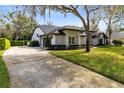 Beautiful home featuring a large driveway, green grass, professional landscaping and mature trees at 1682 Wingspan Way, Winter Springs, FL 32708