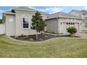 Well-manicured lawn features a mulched garden bed and a young tree at 16936 Champlain St, Clermont, FL 34714