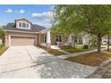 Inviting home with a well-maintained lawn, covered porch, and a convenient two-car garage at 1825 Saffron Plum Ln, Orlando, FL 32828