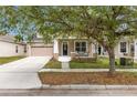 Attractive home showcasing a welcoming front porch, manicured landscaping, and an attached garage at 1825 Saffron Plum Ln, Orlando, FL 32828