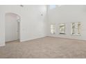 Empty living room featuring neutral carpet, white walls, and bright windows at 1825 Saffron Plum Ln, Orlando, FL 32828