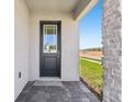 A front door with sidelight and brick facade and gray pavers at 1912 Archer Dr, Minneola, FL 34715