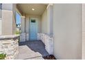 Inviting front porch with stone-accented columns and a stylish blue door, creating a welcoming entrance at 2236 Hen Rd, Minneola, FL 34715