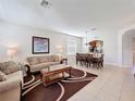 Comfortable living room featuring tile flooring, plush sofas, and a decorative rug at 2530 Holtrock St, Kissimmee, FL 34747