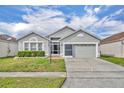 Charming single-story home features a well-maintained lawn and a two-car garage at 2607 Quail Pond Way, Kissimmee, FL 34743