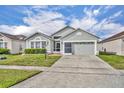 Charming single-story home features a well-maintained lawn and a two-car garage at 2607 Quail Pond Way, Kissimmee, FL 34743