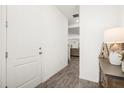 Hallway featuring wood-look floors, white door, and view into the living room at 2710 Bolzano Dr, Apopka, FL 32712
