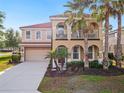 Charming two-story home with a red tile roof, a two-car garage, and a lovely second story balcony at 4200 Oaktree Dr, Davenport, FL 33837
