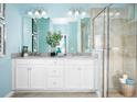 Bathroom with double vanity, white cabinets, large mirror, and walk-in shower, providing plenty of space at 503 Silver Palm Dr, Haines City, FL 33844