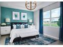 Stylish main bedroom features a large window, blue textured wall and luxurious furnishings, perfect for relaxation at 503 Silver Palm Dr, Haines City, FL 33844