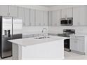 Modern kitchen features stainless steel appliances, an island, and shaker style cabinets at 503 Silver Palm Dr, Haines City, FL 33844