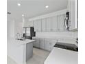 Open concept kitchen with stainless appliances, shaker cabinets, island and quartz countertops at 503 Silver Palm Dr, Haines City, FL 33844
