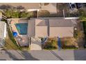 Aerial view of a home featuring a swimming pool, brick-paved patio, and well-manicured lawn at 509 Eastwood Ln, Daytona Beach, FL 32118