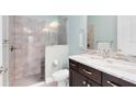 Bathroom showcasing tiled shower, a marble countertop vanity with dark cabinets, and soft lighting at 5509 Meadow Hill Loop, Lady Lake, FL 32159