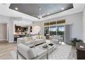 Open-concept living room featuring a dark tray ceiling, tile flooring, and sliders to the pool at 5509 Meadow Hill Loop, Lady Lake, FL 32159