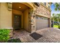 Close-up of a home's entrance, showcasing a brick walkway, two-car garage, and stone accents at 8808 Macapa Dr, Kissimmee, FL 34747