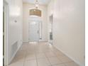 Inviting foyer with tile flooring, a transom window, and a view into the home at 9723 Pecky Cypress Way, Orlando, FL 32836