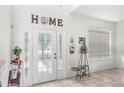 Bright foyer with decorative front door, tiled floor, and high ceilings at 9919 Cypress Knee Cir, Orlando, FL 32825