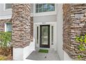Close up of the front door with glass panes and the house number above it at 9919 Cypress Knee Cir, Orlando, FL 32825