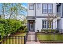 Charming townhome with landscaped front yard and black metal fence, welcoming entrance with wreath at 1010 Lychee Ct, Lake Mary, FL 32746
