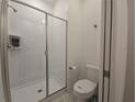 Bright bathroom featuring a tiled shower with sliding glass door and modern fixtures at 1036 Leader Street, Davenport, FL 33896