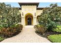 Elegant front entrance with arched doorway, brick pathway, and beautiful landscaping at 11055 Ullswater Ln, Windermere, FL 34786