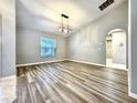 Spacious living room featuring vaulted ceilings, modern light fixture, and beautiful floors at 1200 Montheath Cir, Ocoee, FL 34761