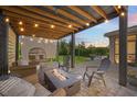 Relaxing covered patio with string lights, comfortable seating, and a modern fire pit for outdoor enjoyment at 12048 Imaginary Way, Orlando, FL 32832