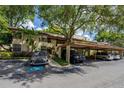 Beige condo with a carport and ample parking spaces covered by mature shade trees at 1270 Saint Tropez Cir # Ge, Orlando, FL 32806