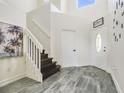 Bright foyer featuring tile flooring and a staircase, creating a grand entrance with lots of natural light at 13208 Canna Lily Dr, Orlando, FL 32824
