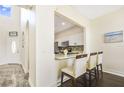 Cozy kitchen with modern appliances, white cabinets, and a breakfast bar with seating for three people at 13208 Canna Lily Dr, Orlando, FL 32824