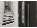 Welcoming entryway featuring a modern staircase with black and white steps, next to a decorative front door at 13429 Fountainbleau Dr # 13429, Clermont, FL 34711