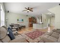 Open-concept living room with a comfortable seating area, ceiling fan, and access to the kitchen at 1530 Tally Cir, Oviedo, FL 32765