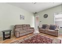 Cozy living room with neutral walls, seating, and a patterned rug on tile flooring at 1530 Tally Cir, Oviedo, FL 32765