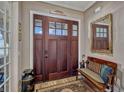 Welcoming foyer featuring a dark wood front door, bench, decorative rug and elegant decor at 200 Valencia Ridge Dr, Auburndale, FL 33823