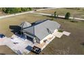 The rear exterior featuring a tile roof, large garage, a turfed backyard space and stone landscaping at 20951 County Road 561, Clermont, FL 34715