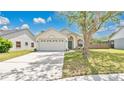 Traditional style home with a two-car garage, neutral color palette and arched entryway at 2381 Pinebrook Ct, Oviedo, FL 32766